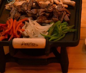 Fajitas servidas na tábua de madeira, ainda no vapor.